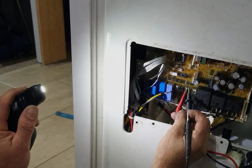 Meter probes on the terminals of a control board still mounted in the appliance